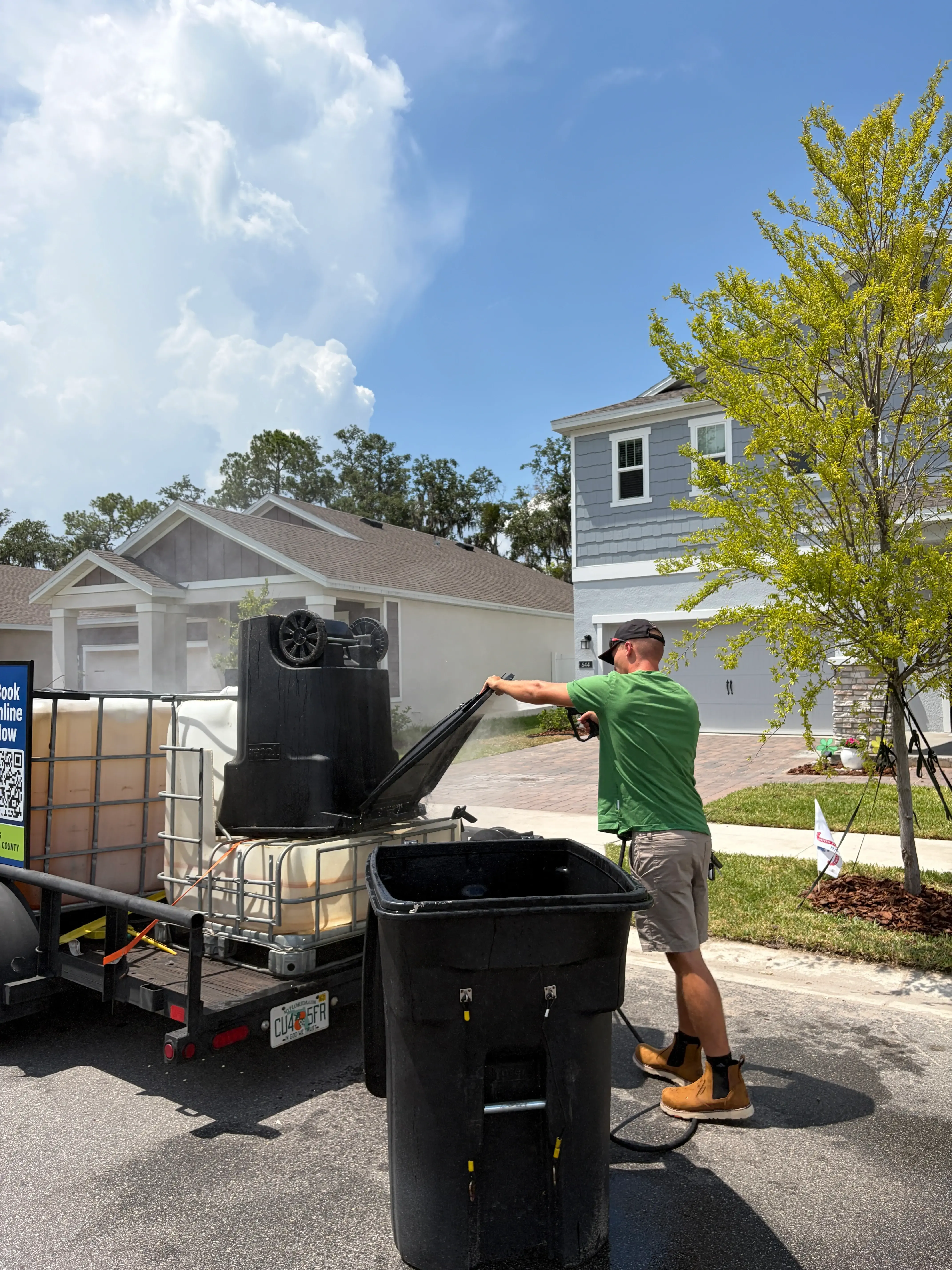 Worker cleaning a trash bin